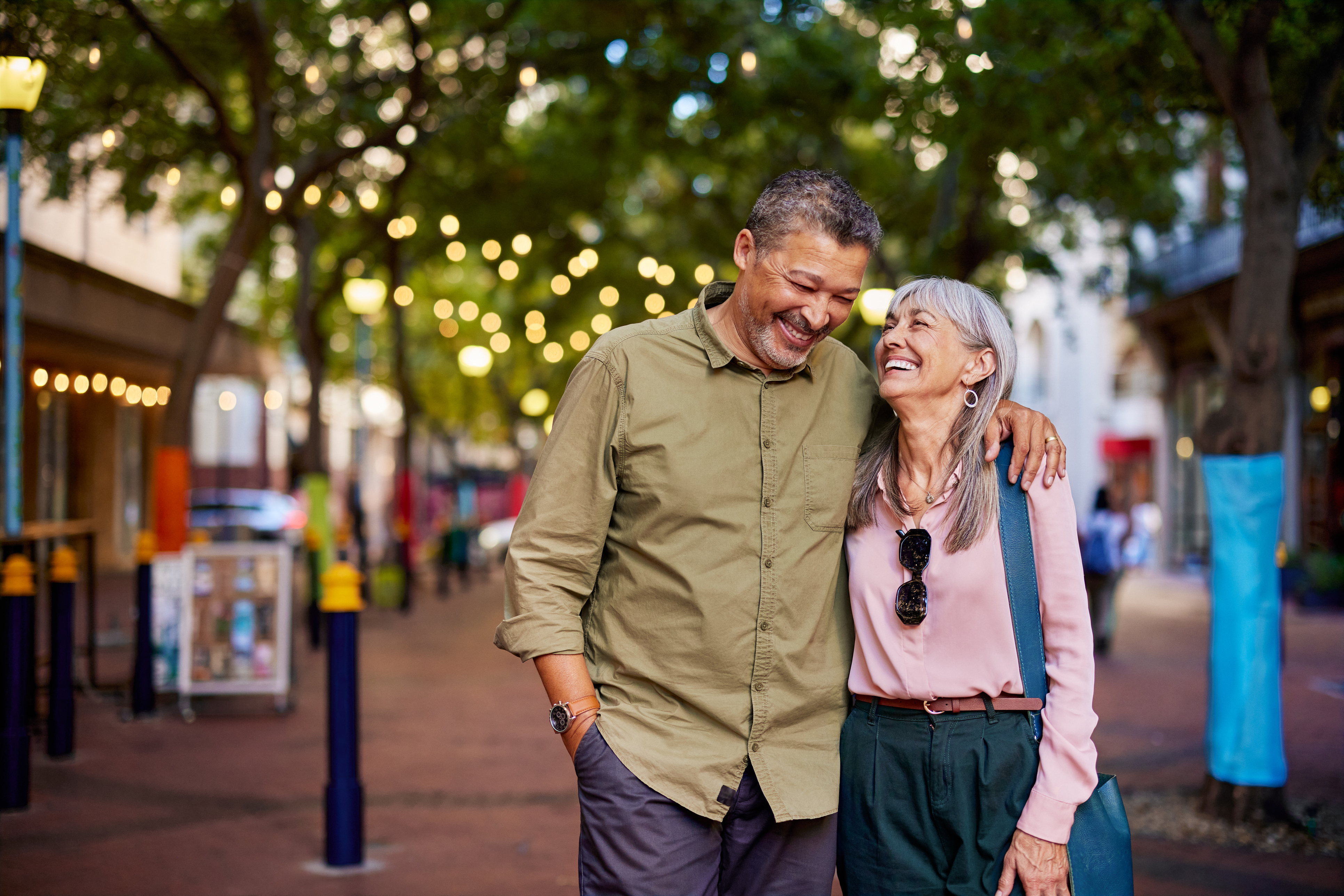 Smiling older couple walks together on a city street