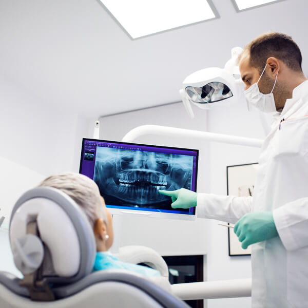 Dentist showing a patient her x-rays on a monitor. 